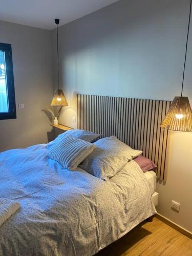 - une chambre avec un lit avec des draps bleus et deux lampes dans l'établissement Gîte avec Jacuzzi Un air de Provence, à Eyguières