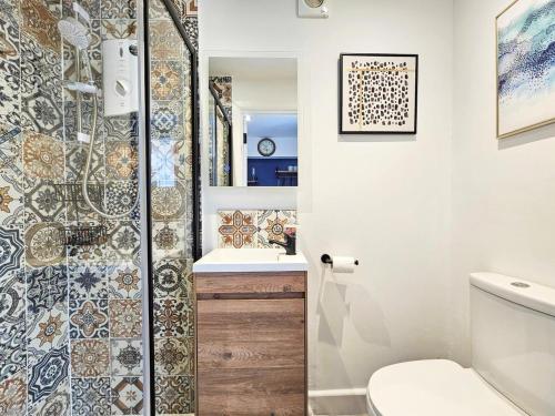 a bathroom with a shower with a toilet and a sink at Cobblestone Studio by Fortuna Property Portfolio in Cheltenham