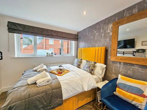 a bedroom with a bed and a mirror and a chair at Cobblestone Studio by Fortuna Property Portfolio in Cheltenham