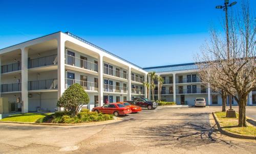 a large building with cars parked in a parking lot at Sweet Dream Inn - University Park in Pensacola