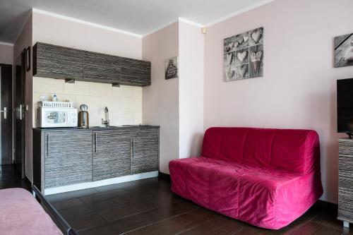 a red couch in a room with a microwave at Villa Pasja in Świnoujście