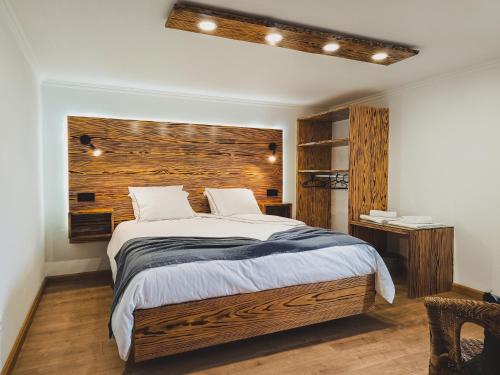 um quarto com uma cama grande e uma parede de madeira em Laura's Cottage AL em Velas