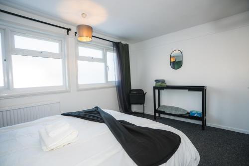 1 dormitorio con cama, ventana y espejo en 1 Bed Flat Tottenham Hale N17 en Londres