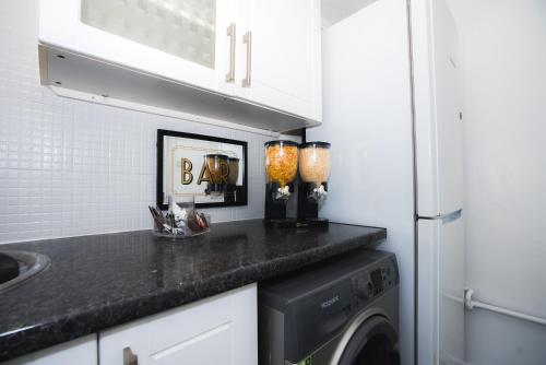 y cocina con lavadora y secadora. en 1 Bed Flat Tottenham Hale N17 en Londres