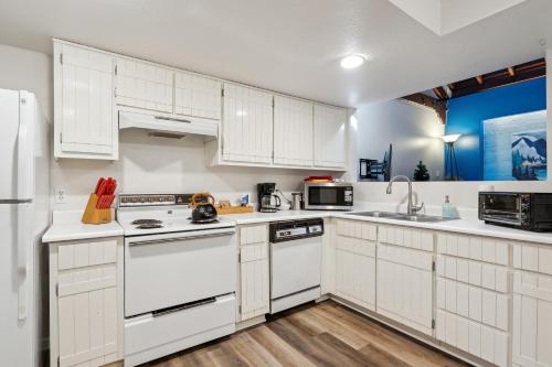 a kitchen with white cabinets and white appliances at THE CARRICK in Bisbee