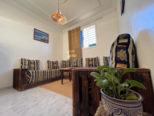 een woonkamer met banken en een tafel en een plant bij Palmsurfexpo in Imsouane