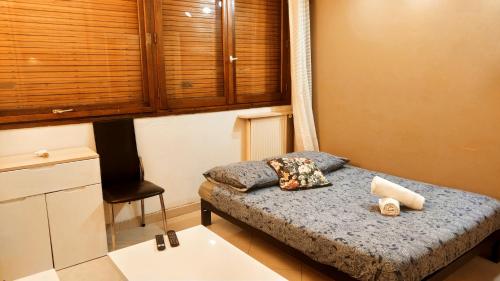 a small bedroom with a bed and a chair at Magnifique Studio du Chateau VLP in Vaux-le-Pénil
