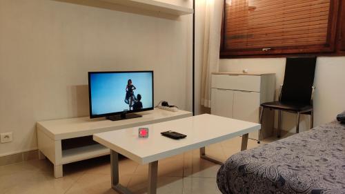 a room with a tv and a table with a bed at Magnifique Studio du Chateau VLP in Vaux-le-Pénil