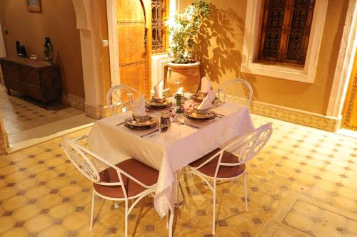 a dining room table with chairs and candles on it at Riad Dar Susan - Authentic Stay in Zagora in Zagora