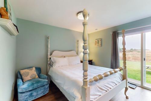 um quarto com uma cama, uma cadeira e uma janela em Breakwater Inn - King Cyrus Condo #9 em Grayland