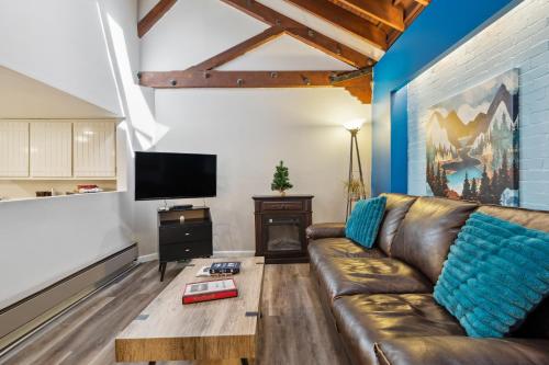 a living room with a leather couch and a tv at THE CARRICK in Bisbee