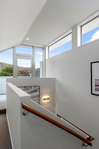 a staircase in a white room with windows at Beachside Bliss - Redcliffs in Christchurch