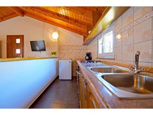 a kitchen with a sink and a white refrigerator at Apartments and Room Adriana in Starigrad