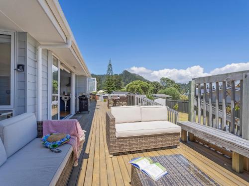 a porch with a couch and chairs on a house at Family Oasis - Pauanui Holiday Home in Pauanui