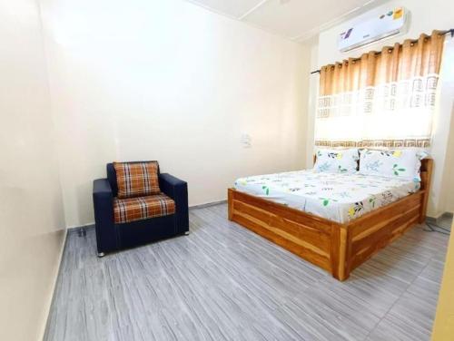 1 dormitorio con 1 cama y 1 silla en Chic Appart Climatisé Wifi 1er Etage, en Lomé