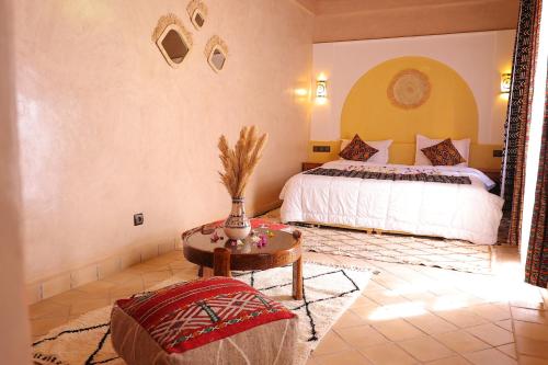a bedroom with a bed and a table in a room at Riad Dar Susan - Authentic Stay in Zagora in Zagora