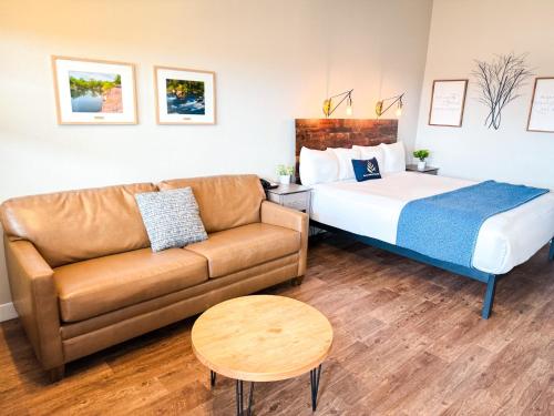 a hotel room with a bed and a couch at PINEMARK Inn Suites Events in Saint Clair