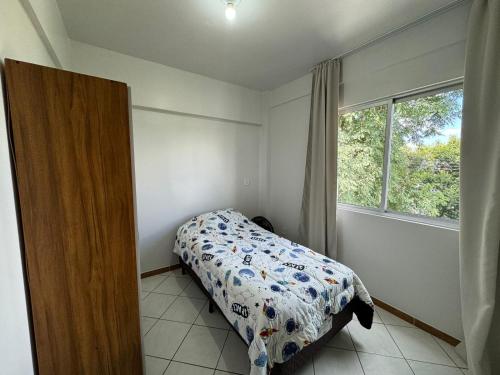 um quarto com uma cama e uma janela em Apartamento com mobília nova 301 em Francisco Beltrão
