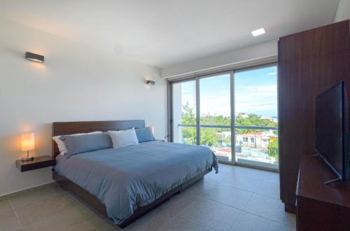 La Poza Suites في إيسلا موخيريس: غرفة نوم بسرير ونافذة كبيرة