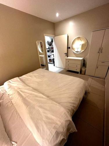 um quarto com uma cama branca e um espelho em شقة خاصة - 205 em Riyadh