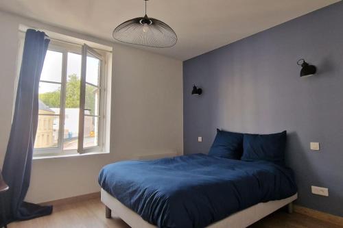 ein Schlafzimmer mit einem blauen Bett und einem Fenster in der Unterkunft Le Prieuré - 4 chambres ensuite (avec salles de bain privative) in Harfleur