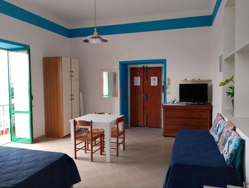 - une chambre avec un lit, une table et une télévision dans l'établissement SEAINSIDE HOUSE - PENISOLA SORRENTINA, à Piano di Sorrento