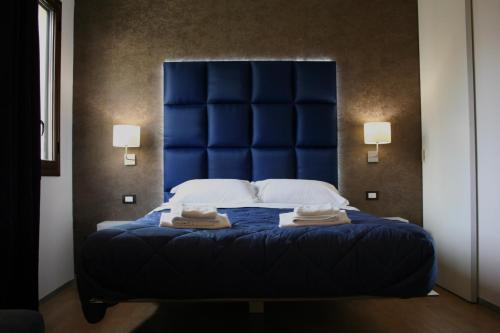 a blue bed with two towels on top of it at Bamboo Luxury B&B in Agrigento