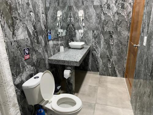 a bathroom with a toilet and a sink at Patty House Galapagos in Puerto Ayora