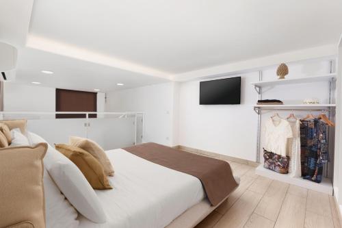 a white bedroom with a bed and a fireplace at Eterea Charming Suites in Sorrento