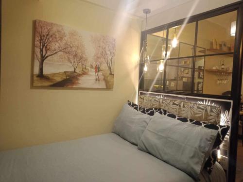 a bedroom with a bed with a painting on the wall at AVIDA ATRIA Tower 3 in Iloilo City