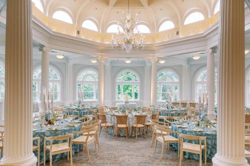 a dining room with tables and chairs and a chandelier at The Omni Homestead Resort in Hot Springs