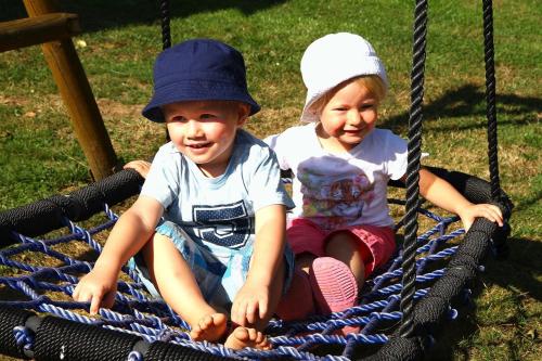 two young children sitting on a swing at Gästehaus Weber in Arrach