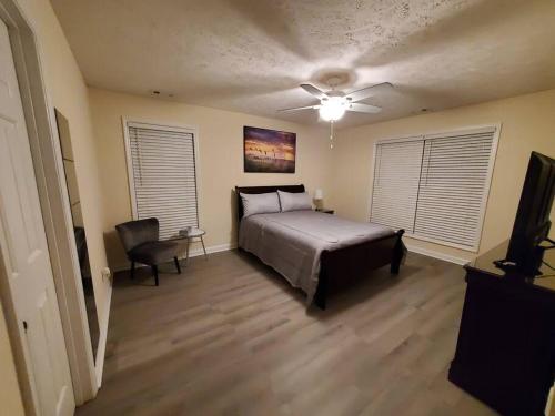 a bedroom with a bed and a ceiling fan at A Touch of Sunshine Ideal For Long Term Stays in Fayetteville