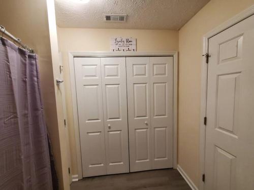 a bathroom with a white door and a closet at A Touch of Sunshine Ideal For Long Term Stays in Fayetteville