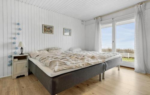 a large bed in a bedroom with a large window at Amazing Home In Føllenslev With Kitchen in Føllenslev