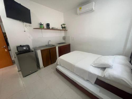 een kleine slaapkamer met een bed en een wastafel bij Apartaestudio Playa Linda 101 in Coveñas