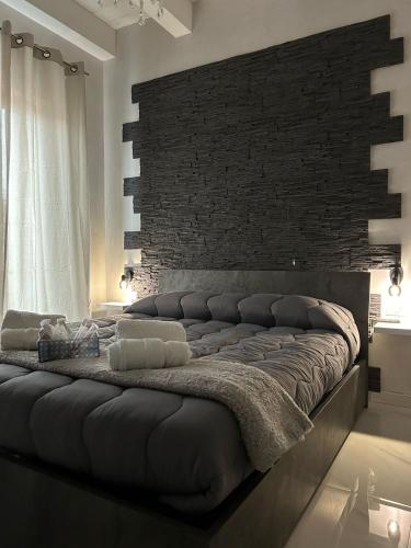 a large bed in a room with a brick wall at B&B Il Sogno in Lamezia Terme
