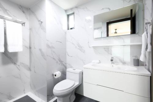 La Poza Suites في إيسلا موخيريس: حمام ابيض مع مرحاض ومغسلة