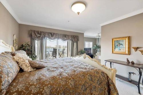 Un dormitorio con una cama y una mesa y una ventana. en Harbor Central Penthouse, en Destin