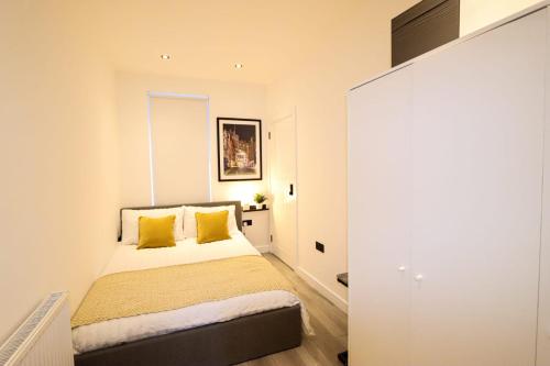 1 dormitorio con 1 cama con almohadas amarillas en City Centre Hub Stirling, On Street Parking., en Stirling