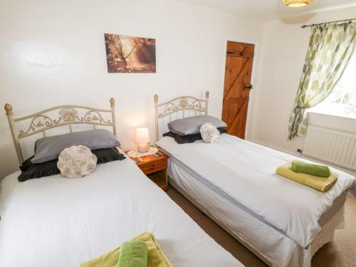 En eller flere senge i et værelse på Woodlands Cottage