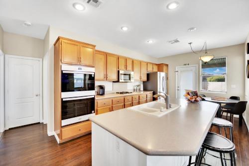 a kitchen with a sink and a stove top oven at Seven Palms in Henderson