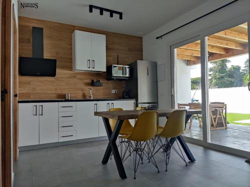 a kitchen with white cabinets and a table and chairs at Novoasis in Chiclana de la Frontera