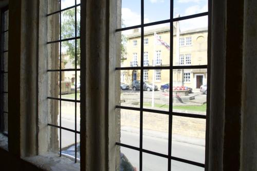 an open window with a view of a street at Badgers Hall in Chipping Campden