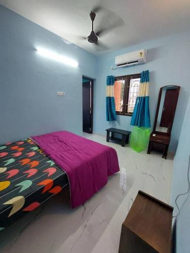 a bedroom with a bed with a purple blanket at The Breezy Place in Chennai