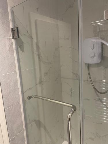 a shower with a glass door in a bathroom at Budget Central Serviced Studio Apartment in Sunderland