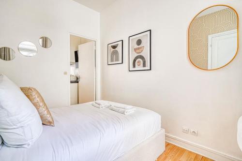 - une chambre blanche avec un lit blanc et un miroir dans l'établissement Appartement équipé quartier Montparnasse - II, à Paris
