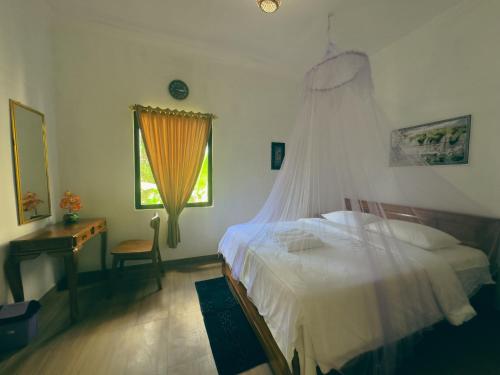 a bedroom with a bed and a dresser and a window at Homestay Sente in Munduk