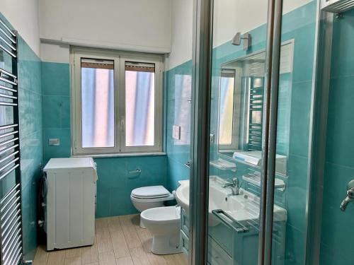 a blue bathroom with a toilet and a sink at Sperlonga Paradise Central Apartment in Sperlonga