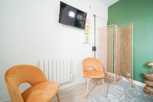 een kamer met 2 stoelen en een tv aan de muur bij Green studio cosy and confortable - IV in Parijs